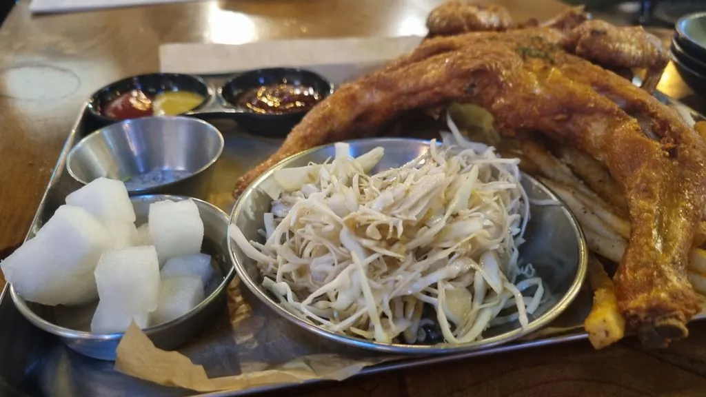 먹기 좋게 손질된 통닭과 곁들여 먹기 좋은 양배추 샐러드, 치킨무
